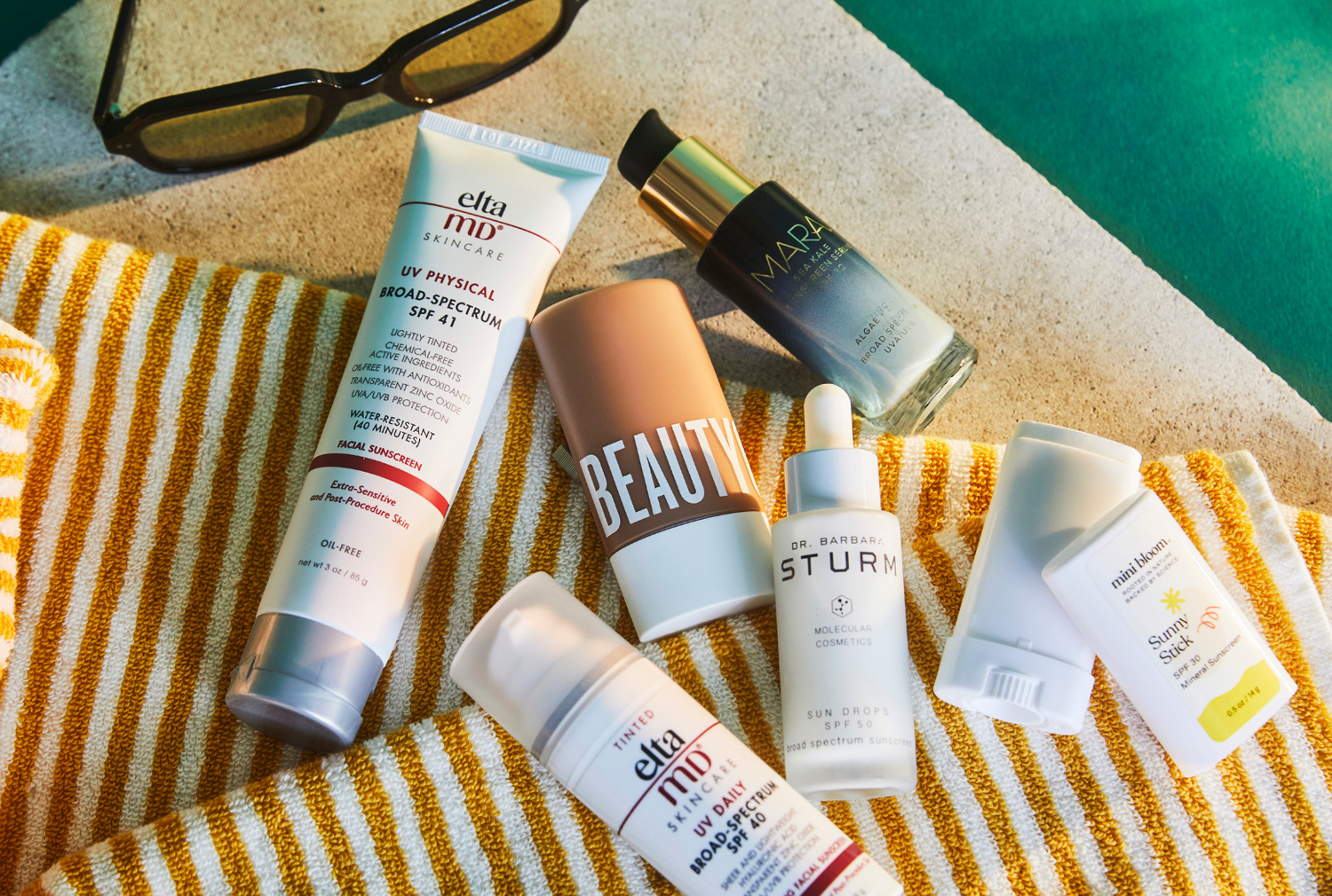 Collection of Sunscreens on beach blanket